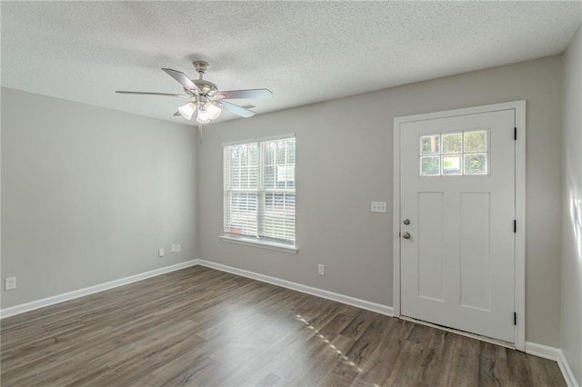 foyer entrance with ceiling fan, dark hardwood / wood-style floors, and a textured ceiling