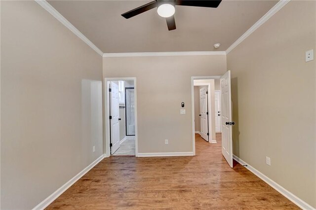 unfurnished bedroom with baseboards, a ceiling fan, light wood-style flooring, ornamental molding, and ensuite bathroom