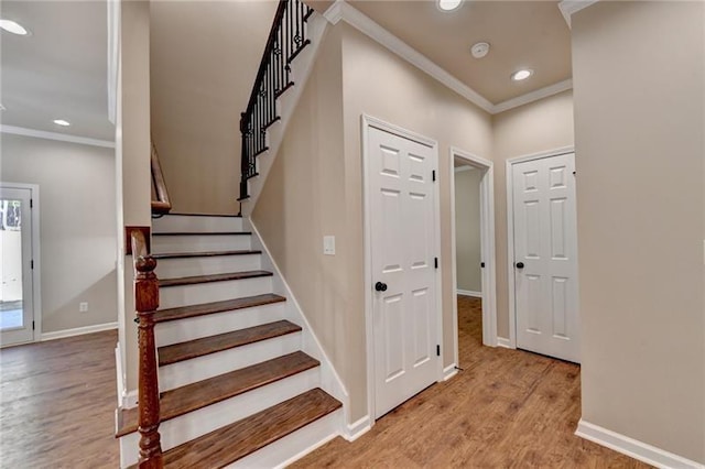 staircase featuring ornamental molding, recessed lighting, baseboards, and wood finished floors