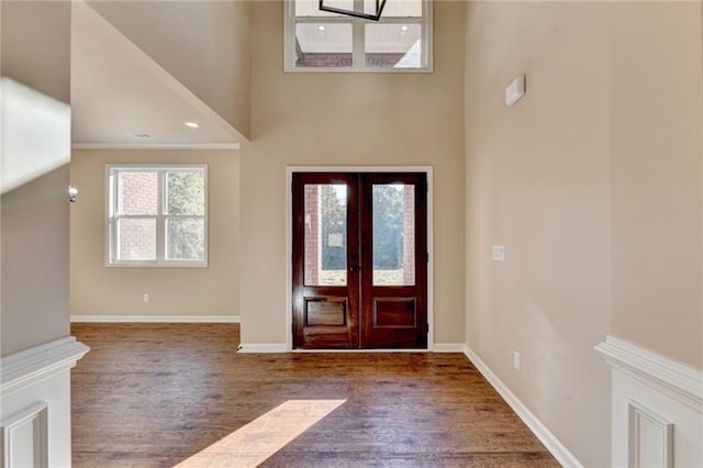 entryway with crown molding, baseboards, dark wood-type flooring, and french doors