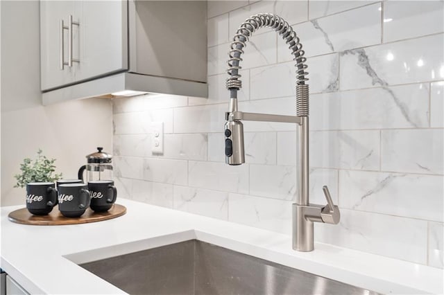 interior details featuring light countertops, white cabinetry, and decorative backsplash