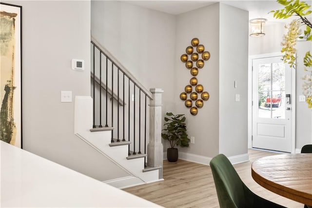 entryway featuring stairs, baseboards, and light wood-style floors