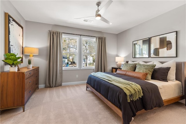 bedroom featuring baseboards, ceiling fan, visible vents, and light colored carpet