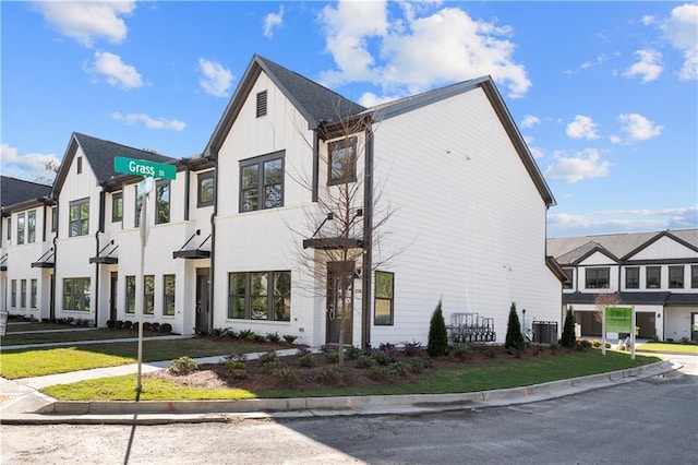 view of front of property with a residential view, a front lawn, and central air condition unit