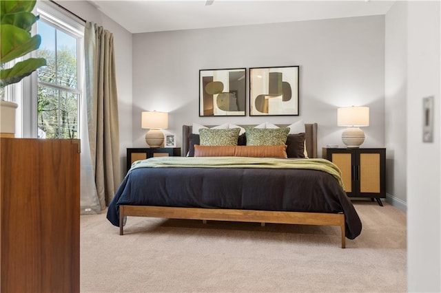 bedroom featuring baseboards and light colored carpet