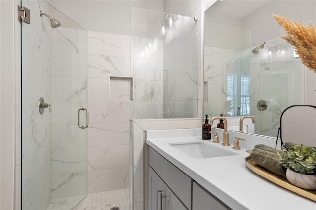 full bathroom featuring a marble finish shower and vanity