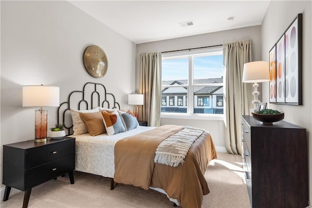 bedroom with visible vents and light carpet