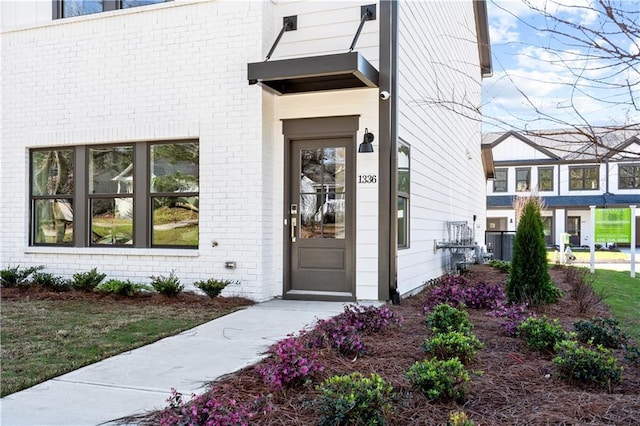 entrance to property featuring brick siding