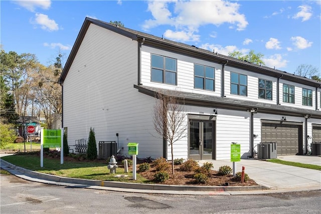 view of front of house with cooling unit, concrete driveway, and an attached garage