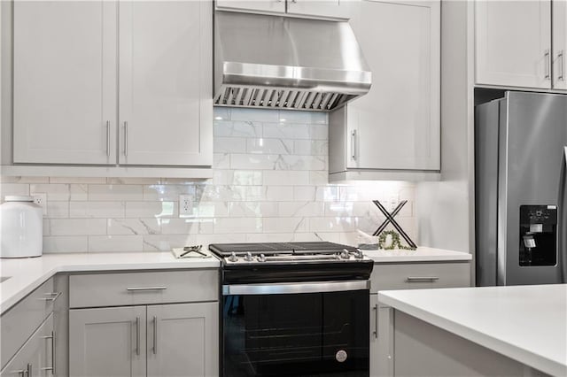 kitchen with stainless steel appliances, decorative backsplash, extractor fan, and light countertops