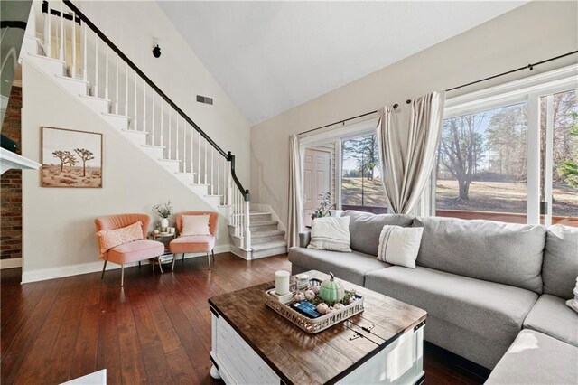 living room with high vaulted ceiling, dark wood-type flooring, and a chandelier