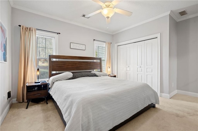 bedroom with light carpet, ceiling fan, crown molding, and a closet