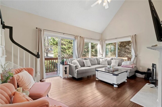 living room with high vaulted ceiling, ceiling fan, and dark wood-type flooring