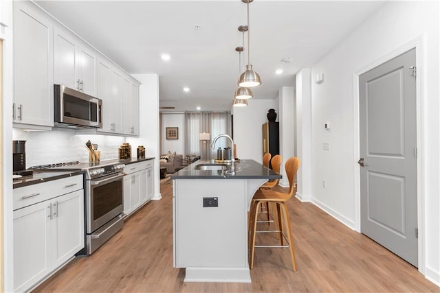 kitchen featuring a sink, decorative backsplash, dark countertops, and stainless steel appliances