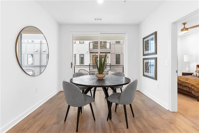 dining room featuring baseboards, wood finished floors, and visible vents
