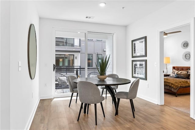 dining space featuring baseboards, visible vents, and wood finished floors