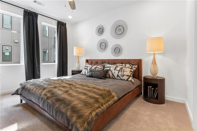 carpeted bedroom with visible vents, baseboards, and ceiling fan