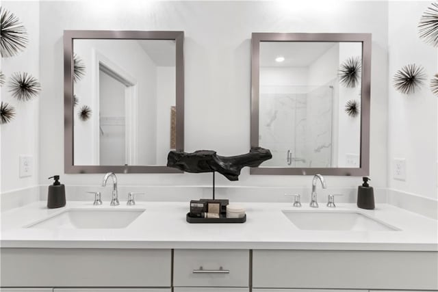 full bath featuring double vanity, a shower stall, and a sink