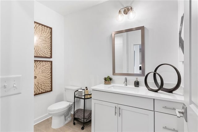 bathroom featuring vanity, tile patterned floors, baseboards, and toilet