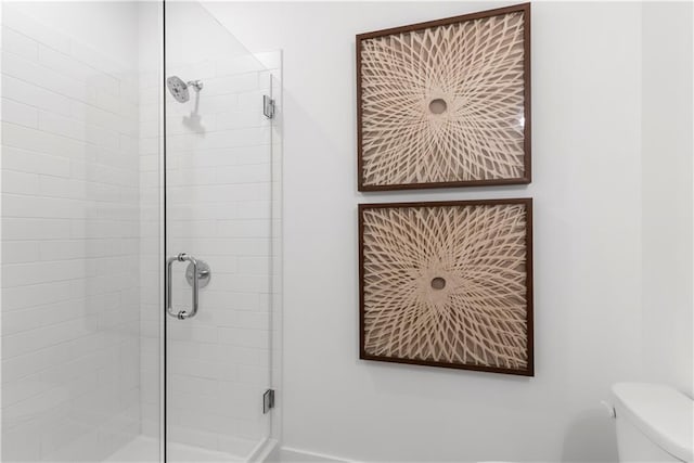 full bathroom featuring a stall shower and toilet