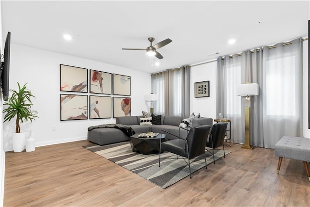 living area with recessed lighting, a ceiling fan, and wood finished floors