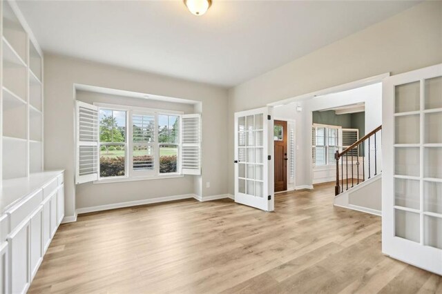 spare room with french doors and light wood-type flooring