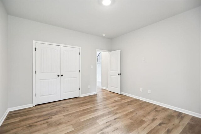 unfurnished bedroom with a closet and light hardwood / wood-style flooring