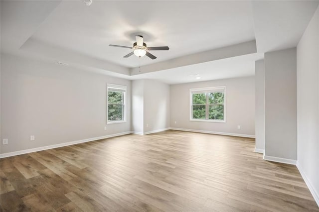 unfurnished room with light hardwood / wood-style flooring, ceiling fan, and a healthy amount of sunlight