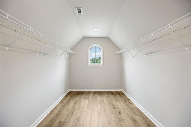 spacious closet featuring wood-type flooring and lofted ceiling