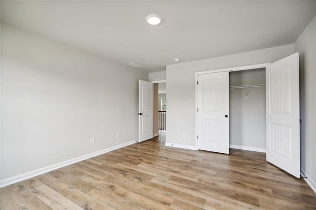 unfurnished bedroom with light hardwood / wood-style floors and a closet