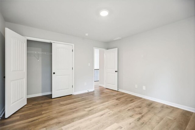 unfurnished bedroom with a closet and light wood-type flooring