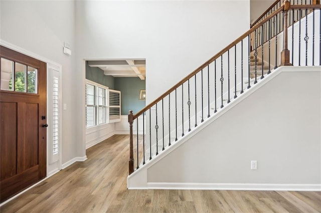 entryway featuring beam ceiling, light hardwood / wood-style floors, and coffered ceiling