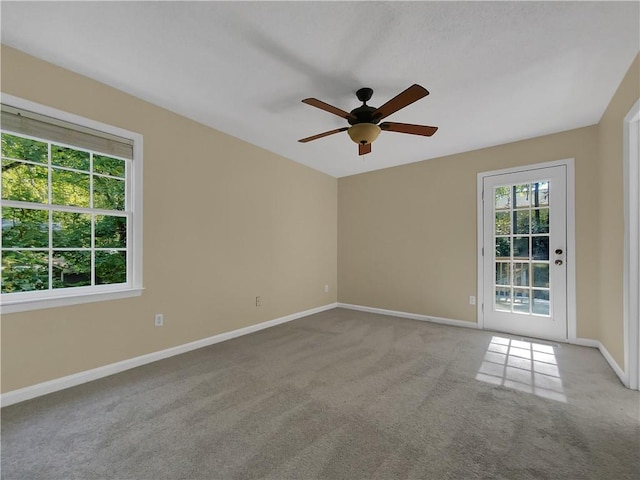 carpeted spare room featuring ceiling fan