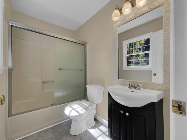 full bathroom with vanity, toilet, tile patterned floors, and bath / shower combo with glass door