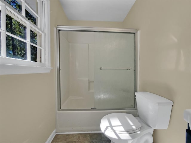 bathroom with toilet and enclosed tub / shower combo