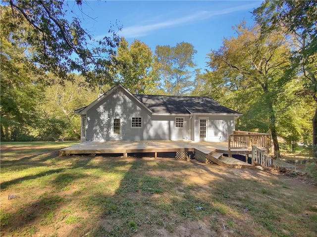 rear view of house with a wooden deck and a yard