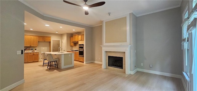 4230 Glen Vista Ct, Duluth, GA 30097 - kitchen featuring ceiling fan, a sink, crown molding, stainless steel double oven, and light wood-style floors