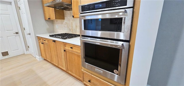 4230 Glen Vista Ct, Duluth, GA 30097 - kitchen with stainless steel appliances, decorative backsplash, light wood-type flooring, ventilation hood, and light countertops