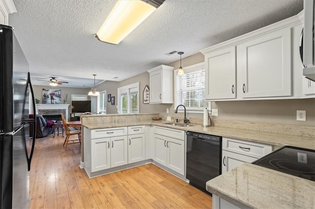 kitchen with white cabinets, dishwasher, kitchen peninsula, and stainless steel refrigerator