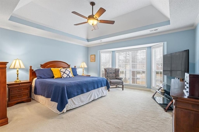 bedroom featuring ceiling fan, light carpet, and a tray ceiling