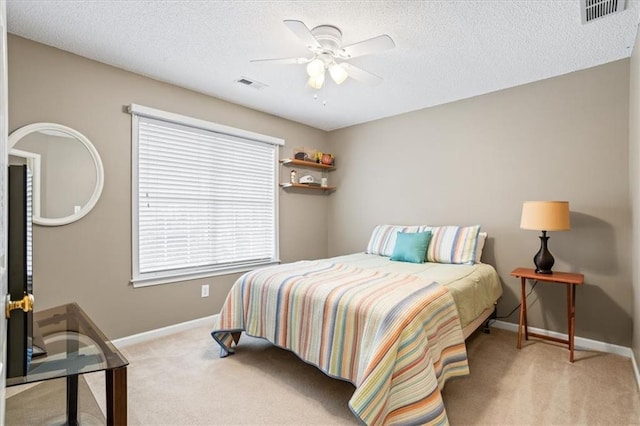 carpeted bedroom with a textured ceiling and ceiling fan