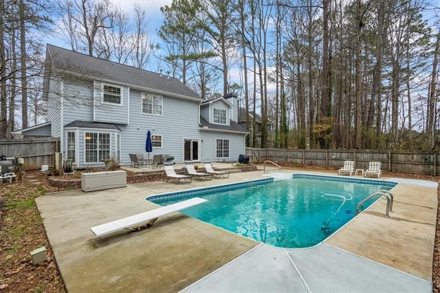 view of pool featuring a patio area and a diving board