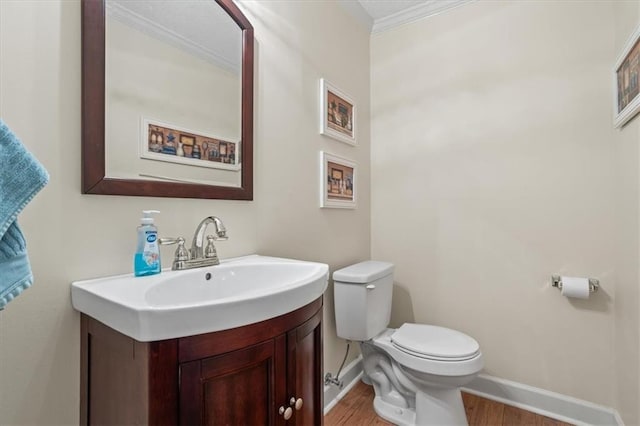 bathroom featuring vanity, toilet, wood-type flooring, and crown molding