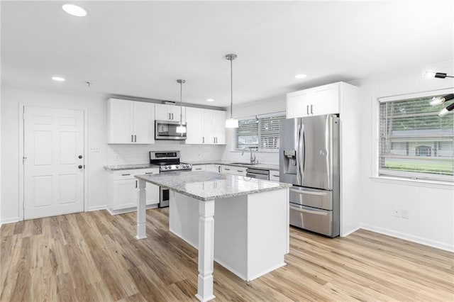 1966 Briarwood Dr, Gainesville, GA 30501 - kitchen featuring appliances with stainless steel finishes, a sink, backsplash, a kitchen island, and white cabinets