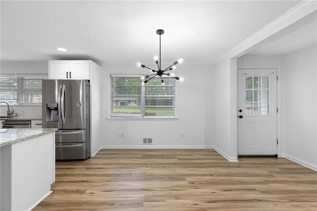 1966 Briarwood Dr, Gainesville, GA 30501 - kitchen with stainless steel fridge with ice dispenser, ornamental molding, a chandelier, plenty of natural light, and light stone counters