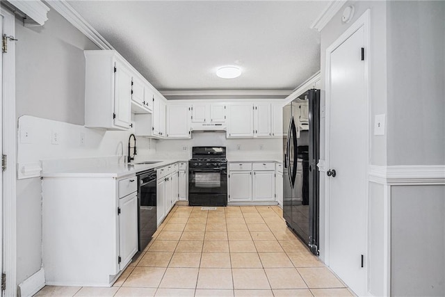 kitchen with under cabinet range hood, light countertops, black appliances, a sink, and light tile patterned flooring