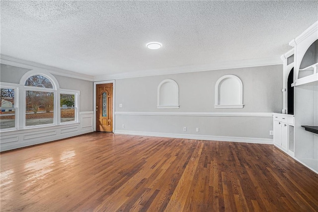 unfurnished living room featuring a textured ceiling, ornamental molding, wood finished floors, and baseboards