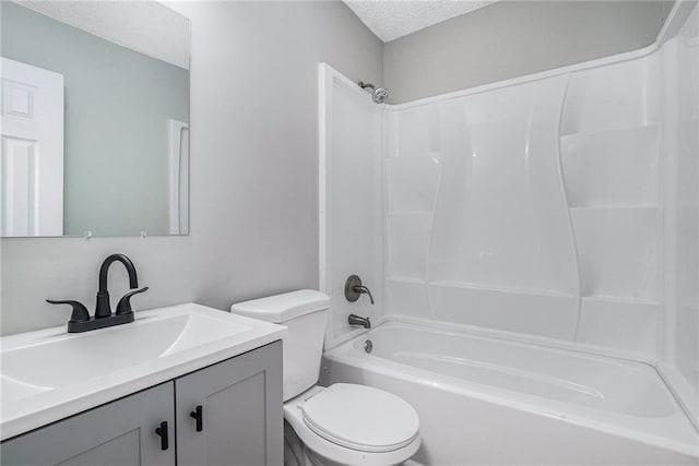 bathroom with a textured ceiling, shower / bath combination, vanity, and toilet