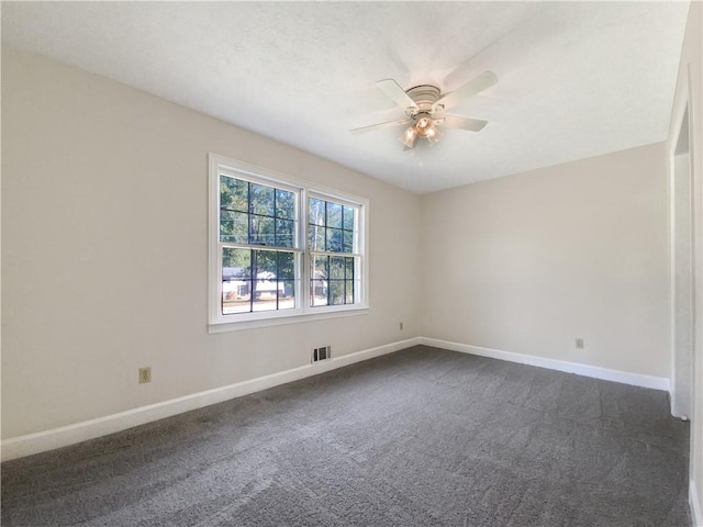 empty room featuring dark carpet and ceiling fan