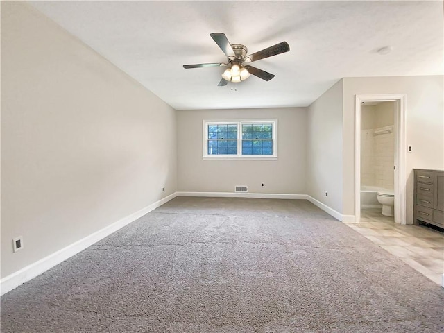 unfurnished bedroom featuring light carpet, ceiling fan, and connected bathroom